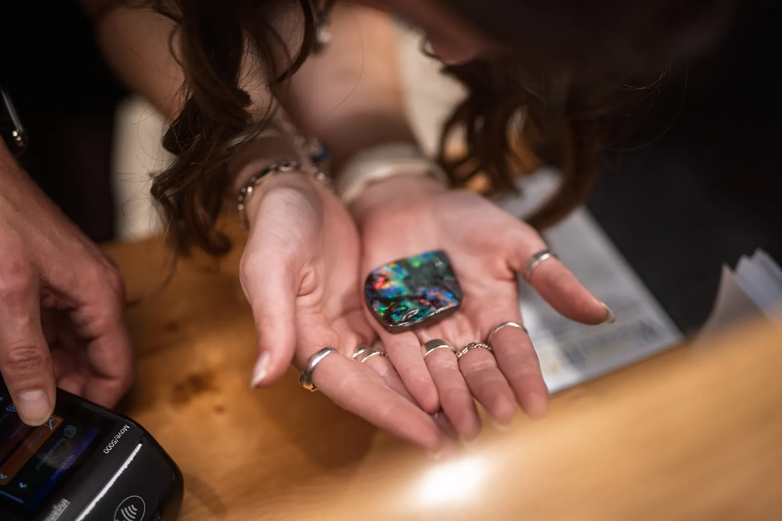 Ein geschliffener Opal in einer offenen Hand
